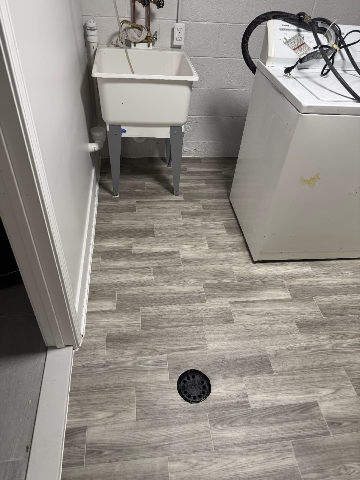 Gray luxury vinyl plank flooring in a laundry room
